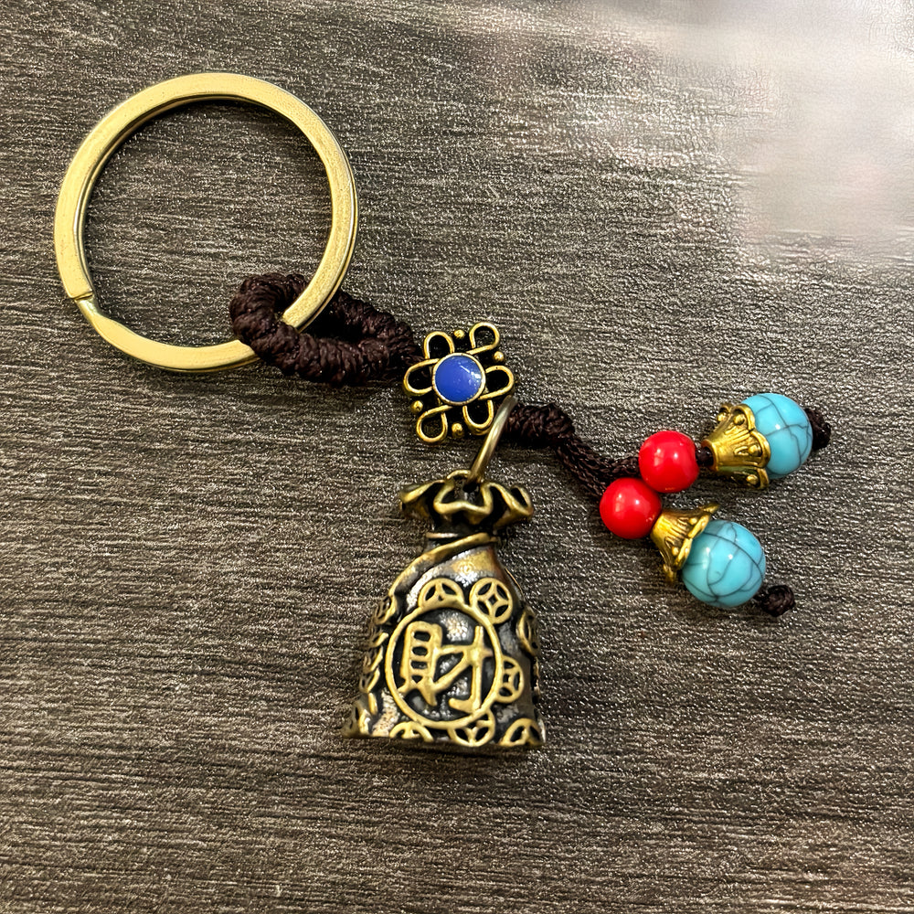 Brass money bag keychain with green bead cord